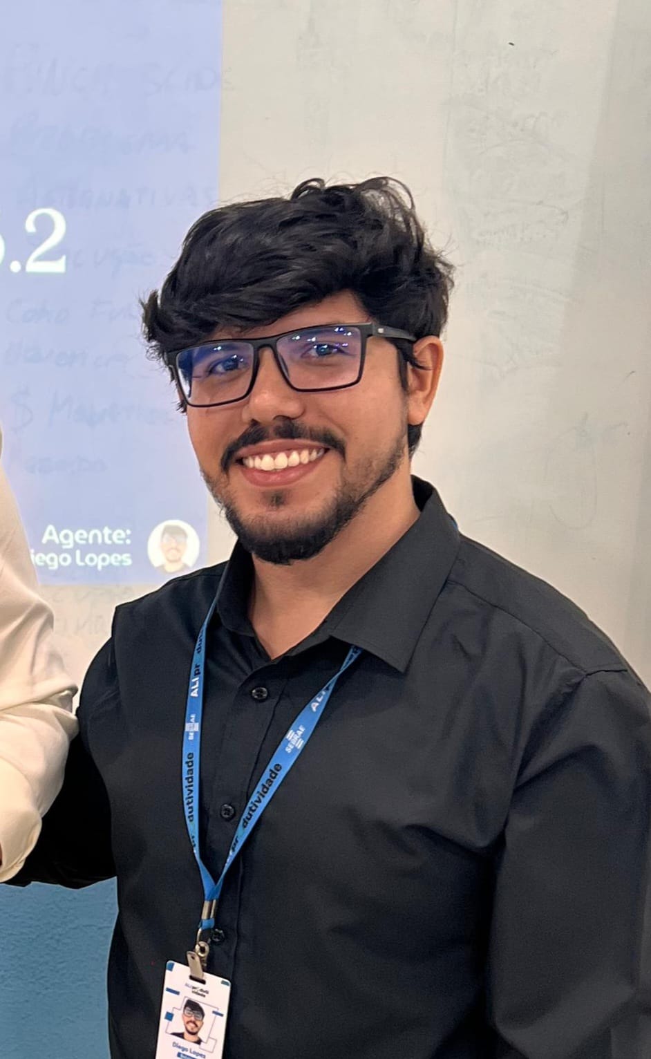 Diego Lopes sorrindo, de óculos e camisa preta